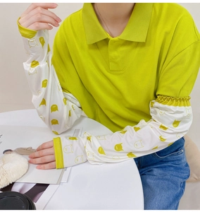 Detail view of white ice silk sun sleeves featuring cute yellow cartoon cat prints