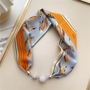 Detail der bedruckten Seidenschal-Halskette mit Blumenmuster und magnetischer Diamantschnalle