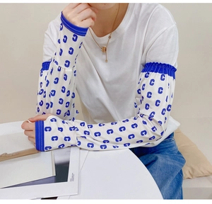 Detail of white cooling sun sleeves with blue C-letter print and fingerless design