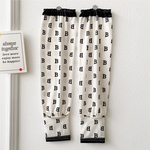 Close-up of off-white sun protection cooling sleeves with black B-letter pattern print