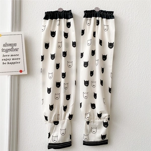Close-up of off-white cooling arm sleeves with cute cartoon cat patterns and elastic cuffs