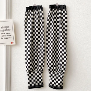 Close-up of black and white checkerboard sun protection sleeves with elastic cuffs