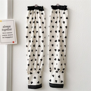 Detail of white cooling arm sleeves with black heart prints and ruffled elastic cuffs