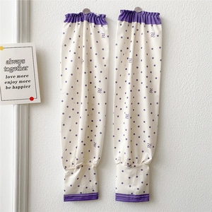 Close-up of white sun sleeves with purple polka dots and elastic bands for arm protection