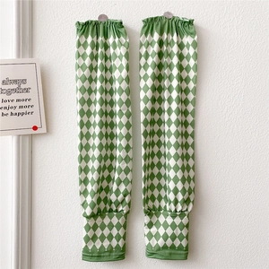 Close-up of green diamond checkered sun protection arm sleeves with elastic cuffs