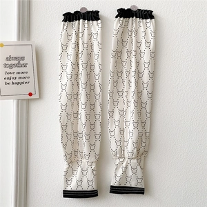 Close-up of cream ice silk sun sleeves with black bear pattern and elastic cuffs