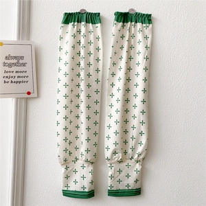 Detail of white cooling arm sleeves with green floral pattern and elastic cuffs