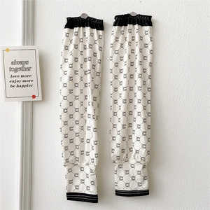 Detail of white ice silk sun sleeves with black monogram pattern and elastic cuffs