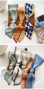 Detail of pleated long scarves in various colors and polka dot patterns on white background