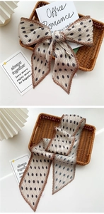 Detail of pleated champagne polka dot silk scarf tied on a rustic wicker basket
