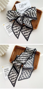 Close-up of black and white houndstooth pleated scarf with elegant accordion fold texture