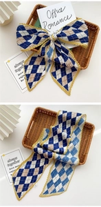 Detail of pleated long scarf with blue and white diamond pattern and yellow edges