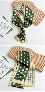 Detail of silk scarf with floral pattern and houndstooth texture on a wooden stand