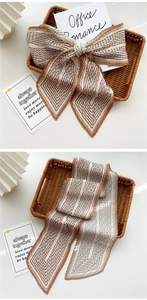 Detail of coffee and beige pleated silk scarf with geometric stripe pattern and satin finish