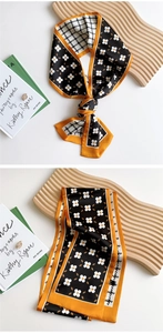 Detail of floral and houndstooth pattern narrow silk scarf with orange contrast edges