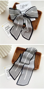 Detail of pleated black and white striped silk scarf with elegant accordion texture