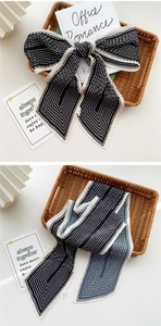 Macro detail of pleated long scarf with black and white geometric stripes and texture