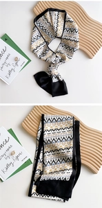 Close-up of vintage geometric pattern on narrow silk scarf with premium black hem details