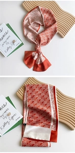 Macro shot of geometric pattern neck scarf in deep orange and cream silk-like fabric