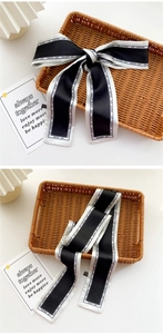 Detail of silk twilly scarf with black and white contrast and decorative text