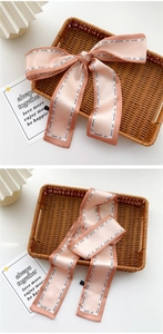 Macro detail of a pink satin skinny scarf with fashion girl print on a woven basket