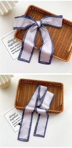 Macro detail of purple satin silk scarf with fashion lettering and ribbon bow knot