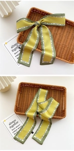Detail of silk satin scarf with yellow and green patchwork and stylish typography