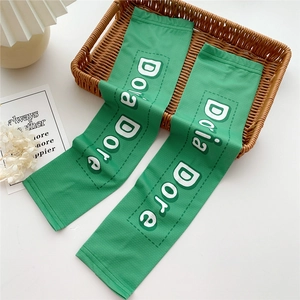 Detailed macro view of green cooling arm sleeves with Dora Dore print and breathable mesh