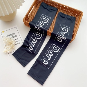 Close-up of black cooling sun protection sleeves featuring white Dora Dore graphic text