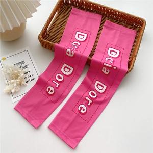 Detailed close-up of pink sun protection arm sleeves with vertical texture and printed logo