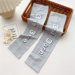 Detail of light gray sun protection arm sleeves featuring Dria Dore lettering print