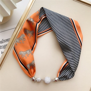 Detail of silk neck scarf with horse print, wavy patterns and sparkling diamond charms