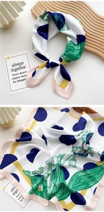 Detail of silk square scarf showing green floral motifs and navy polka dots texture