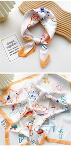 Detail of white square silk scarf featuring cute cartoon bunny and rainbow prints