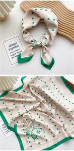 Detail view of 70x70 square silk scarf with green borders and butterfly pattern print