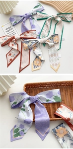 Close-up of printed floral and polka dot silk-like hair scarves on a wooden tray