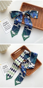 Detail of silk-like narrow scarves with floral patterns and geometric diamonds tied in bows