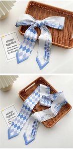 Detail of blue and white checkered silk twilly scarf on a rustic woven tray