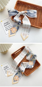 Detail of floral and geometric print twilly scarf with yellow border for bags
