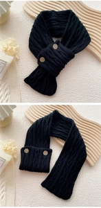 Detail of black cable knit scarf featuring vintage wooden buttons and soft texture