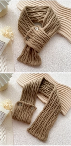 Detail of camel knit scarf with cable pattern and two retro button fasteners
