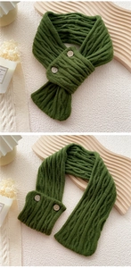 Detail of dark green cable knit scarf with two wooden buttons and warm textured fabric