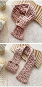 Detail view of pink knit scarf showing wood buttons and classic cable knit texture