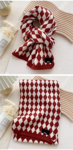 Macro detail of red and white diamond knit scarf with Paris woven label on warm fabric