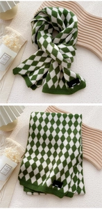 Detail of green and white diamond pattern knit scarf with Paris woven label on ribbed edge