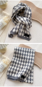 Detail of grey and white argyle knit scarf with black Paris label and ribbed edge finish