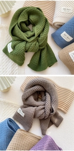 Detail of waffle knit scarves featuring handmade labels in multiple solid colors