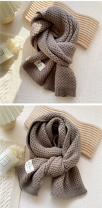 Detail of dark brown chunky knit scarf with honeycomb texture and handmade label