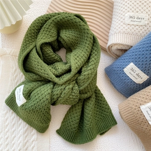 Solid color thick knit scarf in dark green and neutral tones with handmade label