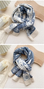 Detail of blue and white knitted scarf featuring Nordic snowflake and geometric patterns